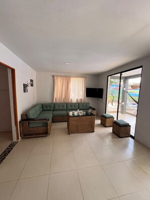 A living room with a sectional sofa, a coffee table, and two ottomans.