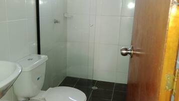 Un baño pequeño con inodoro, lavabo y ducha.