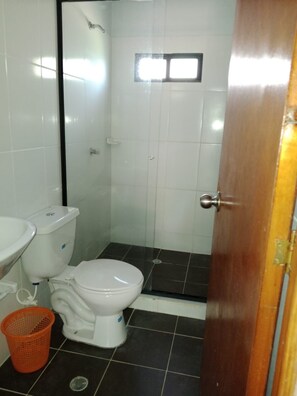 Un baño pequeño con inodoro, lavabo y ducha.