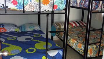 Una cama litera con ropa de cama de colores y estructura metálica.