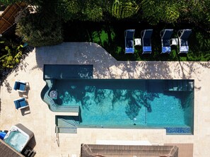 An aerial view of a swimming pool with lounge chairs and a hot tub. - Waterfront Luxe Smart Home | Pool | Gym | Spa (Lantana)