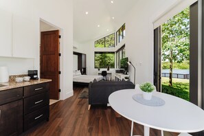 A modern interior with a kitchen, dining area, and bedroom. - Waterfront Luxe Smart Home | Pool | Gym | Spa (Lantana)