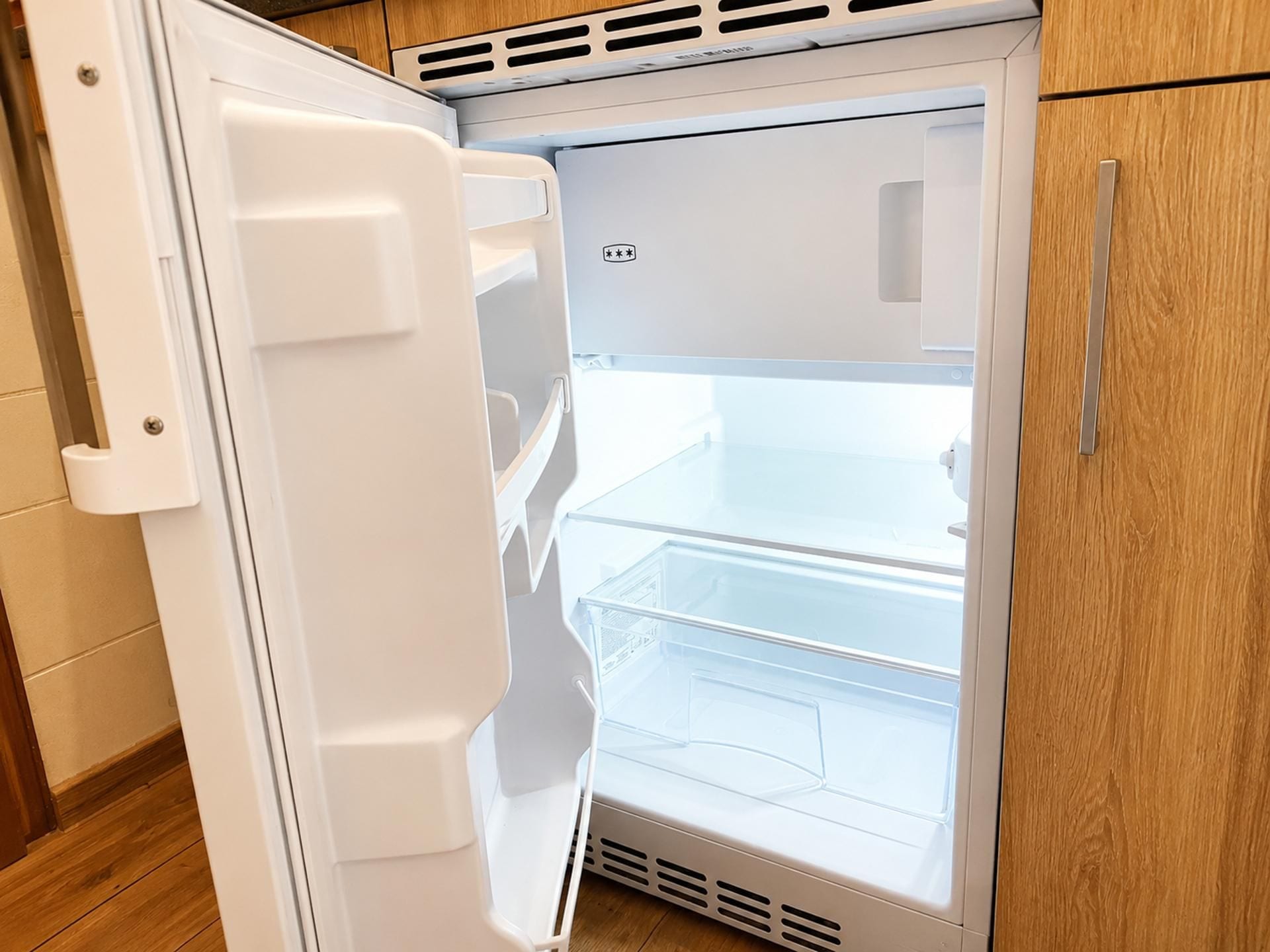 A white refrigerator with a freezer compartment on top and a main compartment below.