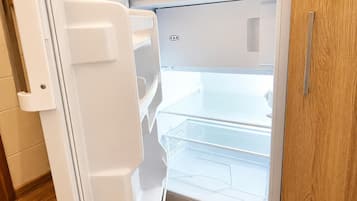 A white refrigerator with a freezer compartment on top and a main compartment below.