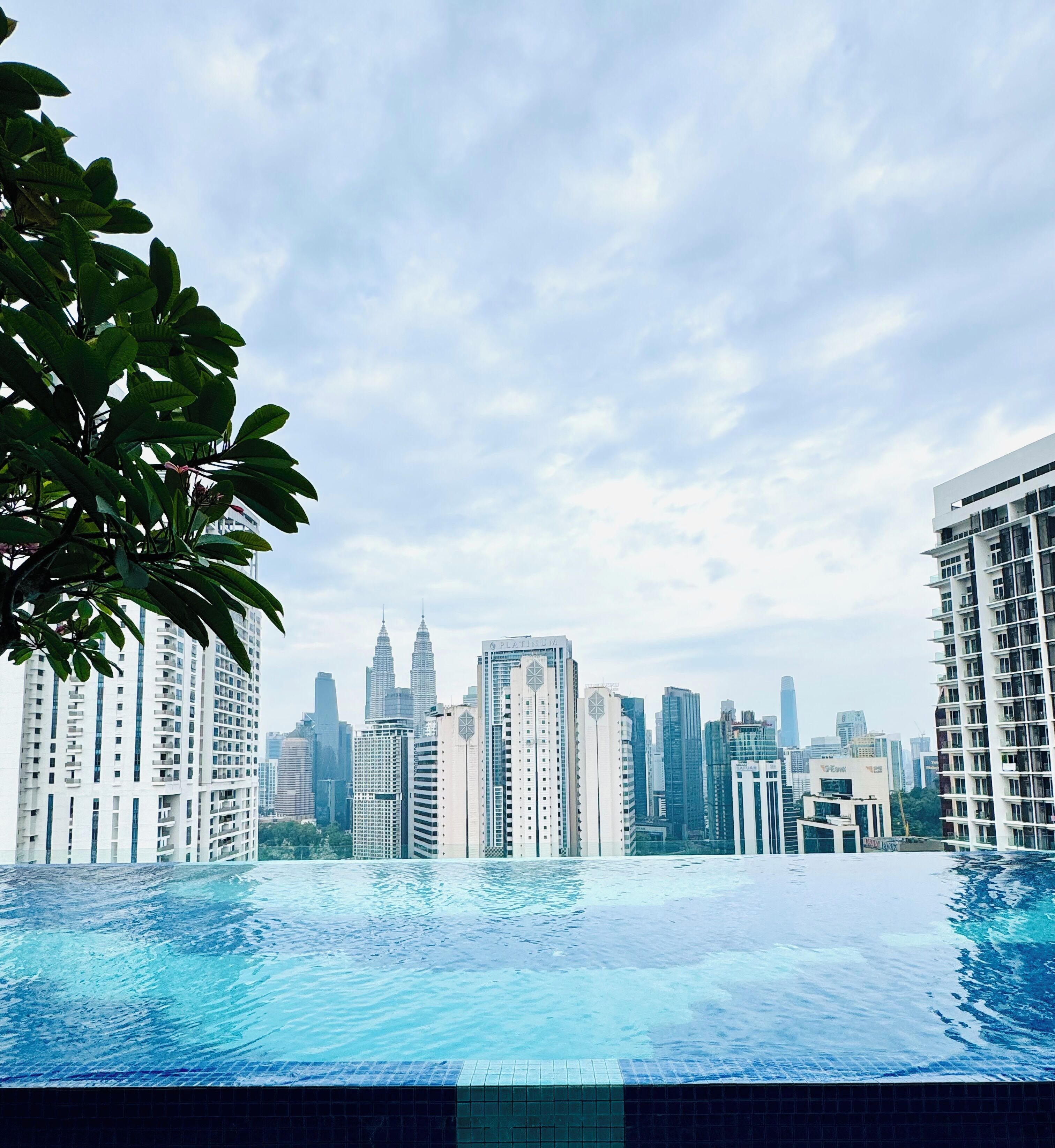 A swimming pool with a city skyline in the background.