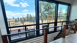 A spacious balcony with a view of a forest and distant buildings. - Chelan Ridge (Chelan)