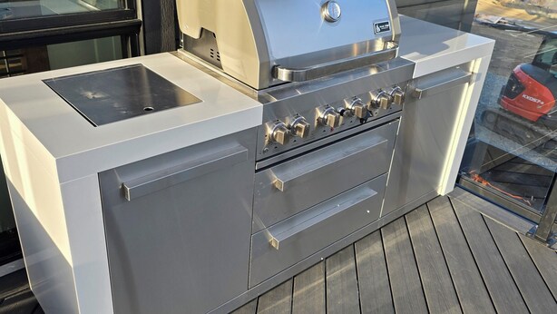 A stainless steel barbecue grill with a digital display, a sink, and a built-in oven on a wooden deck. - Chelan Ridge (Chelan)