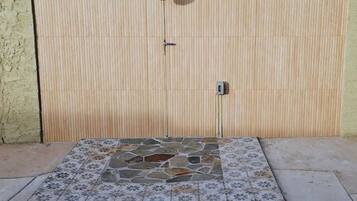 A tiled patio area with a wooden fence in the background.