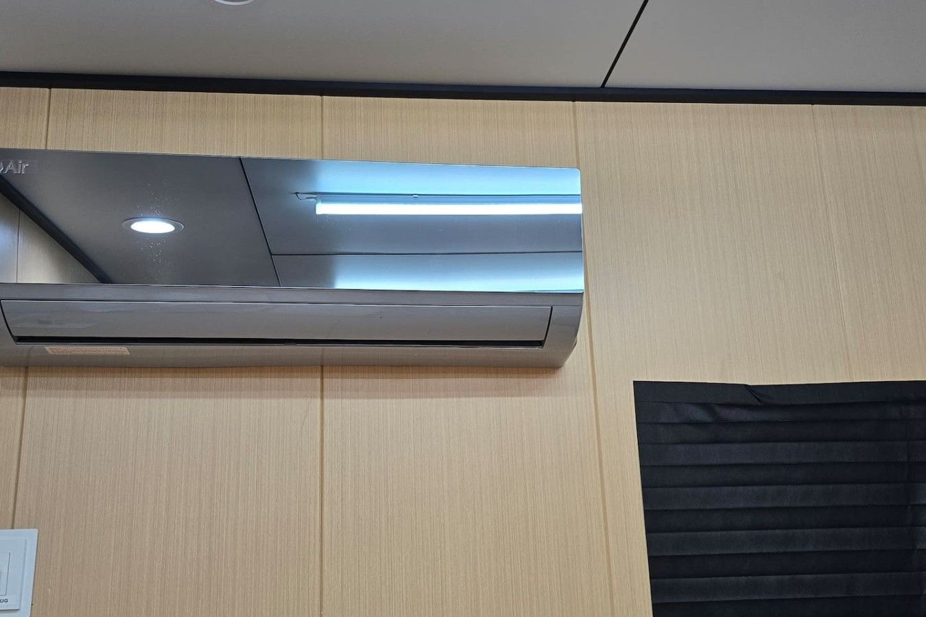 Un climatiseur mural doté d’un panneau de commande et d’une lumière.