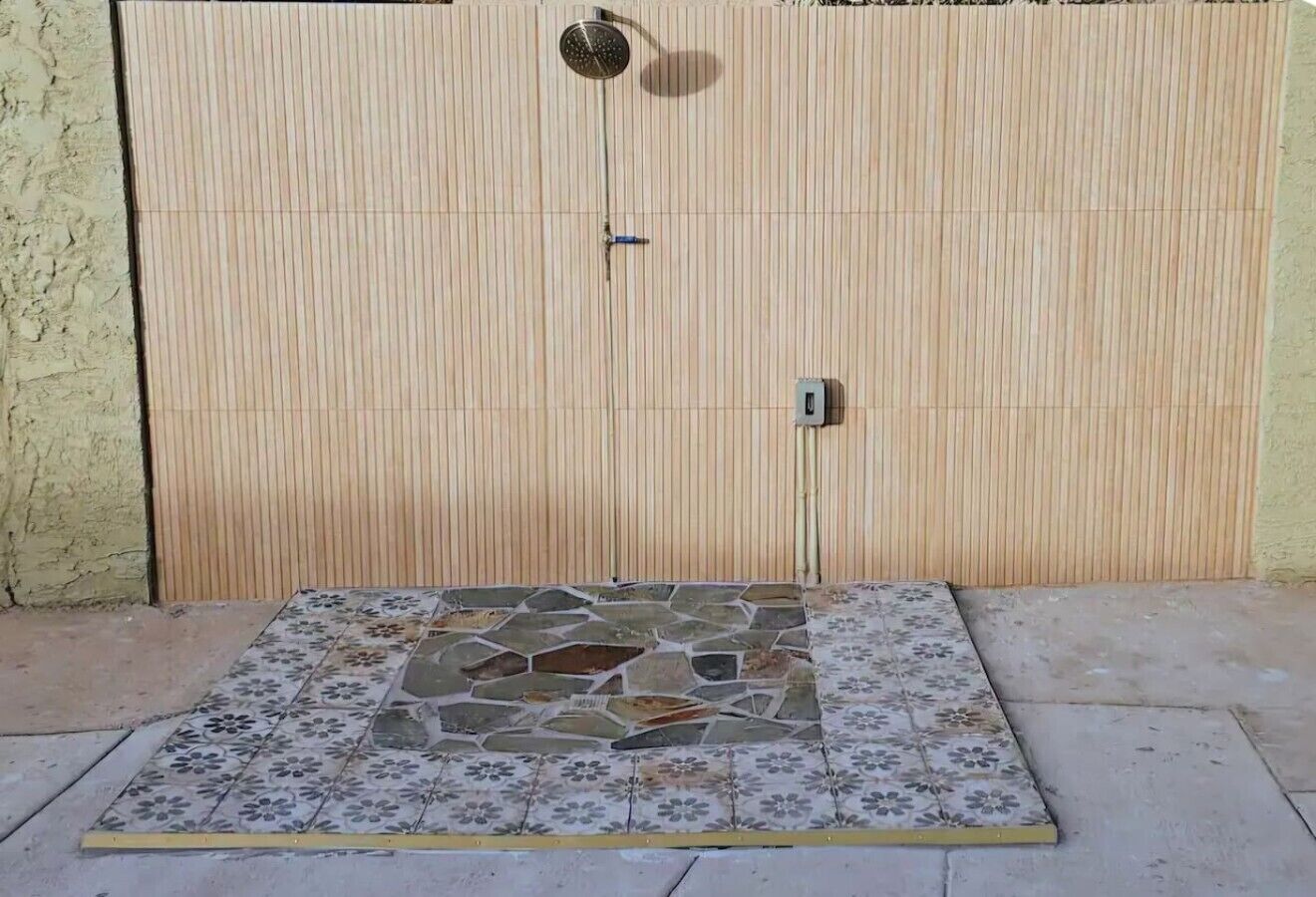 A tiled patio area with a wooden fence in the background.