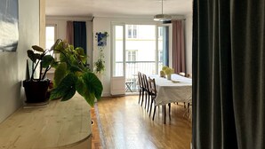 Ein Essbereich mit Tisch und Stühlen, einem Blumentopf und Blick durch ein Fenster.