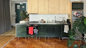 Eine moderne Küche mit Holzausbau, einer zentralen Kochinsel und einem Kühlschrank mit Fotos.