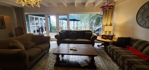 Ein Wohnzimmer mit zwei Sofas, einem Couchtisch und einer Wanduhr.