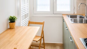 A modern kitchen with a wooden table, a chair, a sink, and a window. - Casa Toli Padua - Self-Check-In, Wi-Fi, 2 Minutes from the Train Station (Padova)