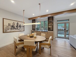 A modern dining area with a round table, chairs, and a pendant light. - Modern Vail Townhome for Families & Friends - 3 Bed + Loft - Close to Bus (Vail)
