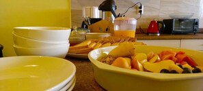 A breakfast setting with bowls of food, a toaster, and a coffee maker. - Casa Rumi  Guesthouse (La Paz)