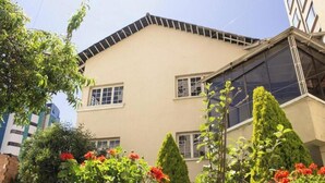 A building with a flat roof, multiple windows, and a balcony.