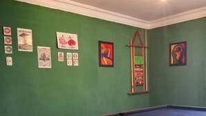 A pool table in a room with green walls and a ceiling fan.