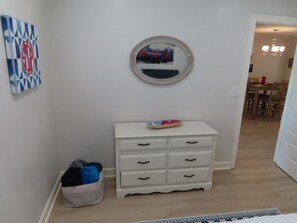 A hallway with a white dresser, a round mirror, and a wall art piece. - Walk to the Grove! Perfect Game Day Condo! (Oxford)