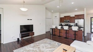 A modern living room with a flat-screen TV, a coffee table, and a large rug. - Des Moines Ranch Retreat (Des Moines)