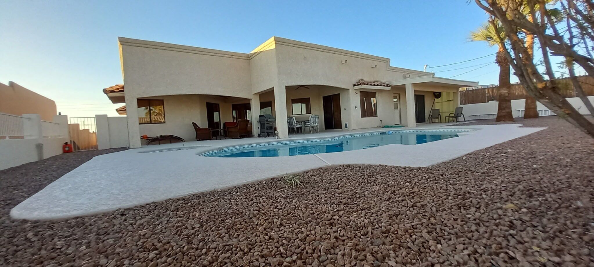 Ein zweistöckiges Gebäude mit Schwimmbad, Außenbereich und einer Terrasse.