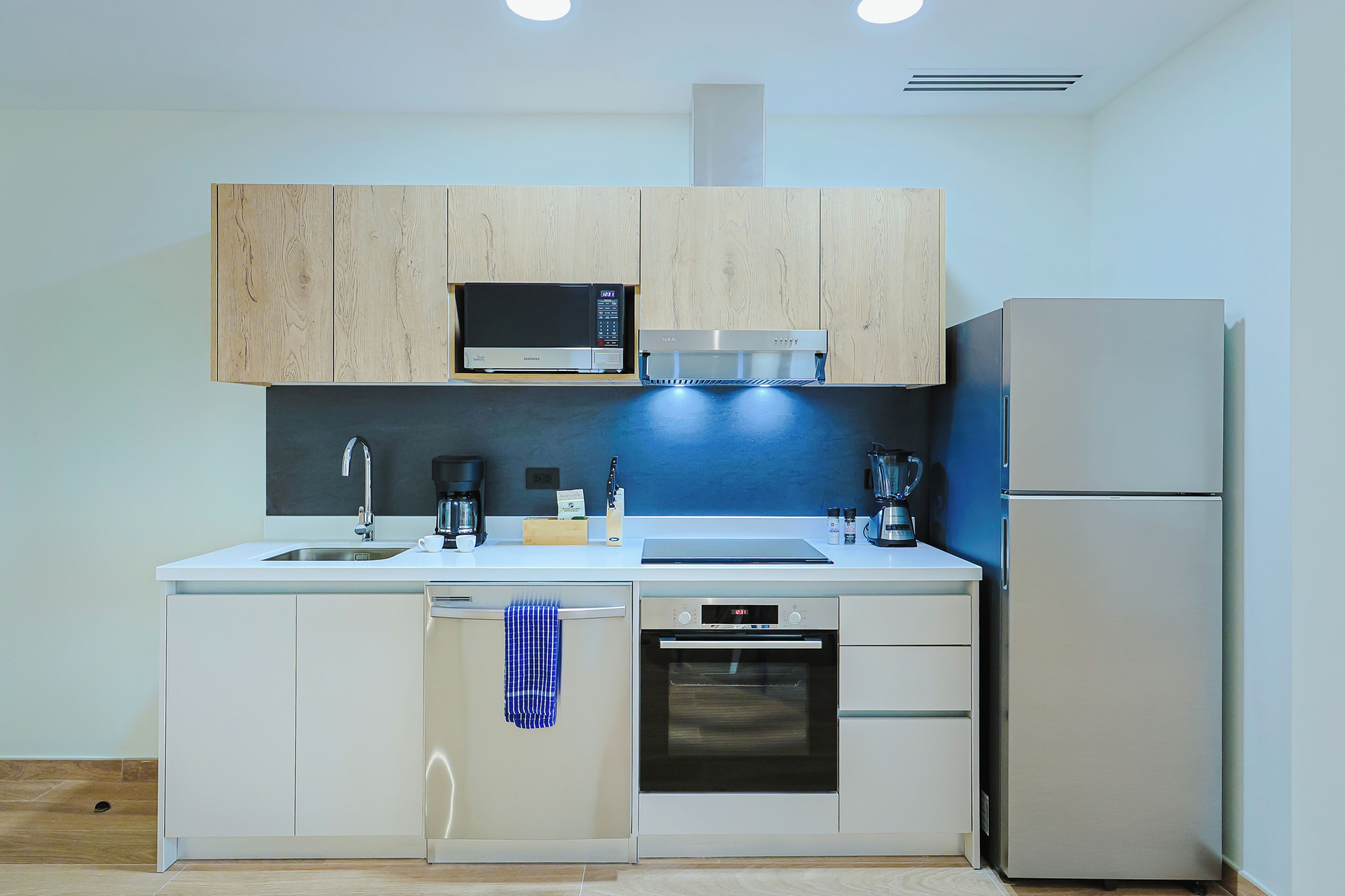 Uma cozinha moderna com micro-ondas, forno e frigorífico embutidos.