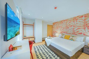 Quarto de hotel com uma cama, televisão, escrivaninha e armário.