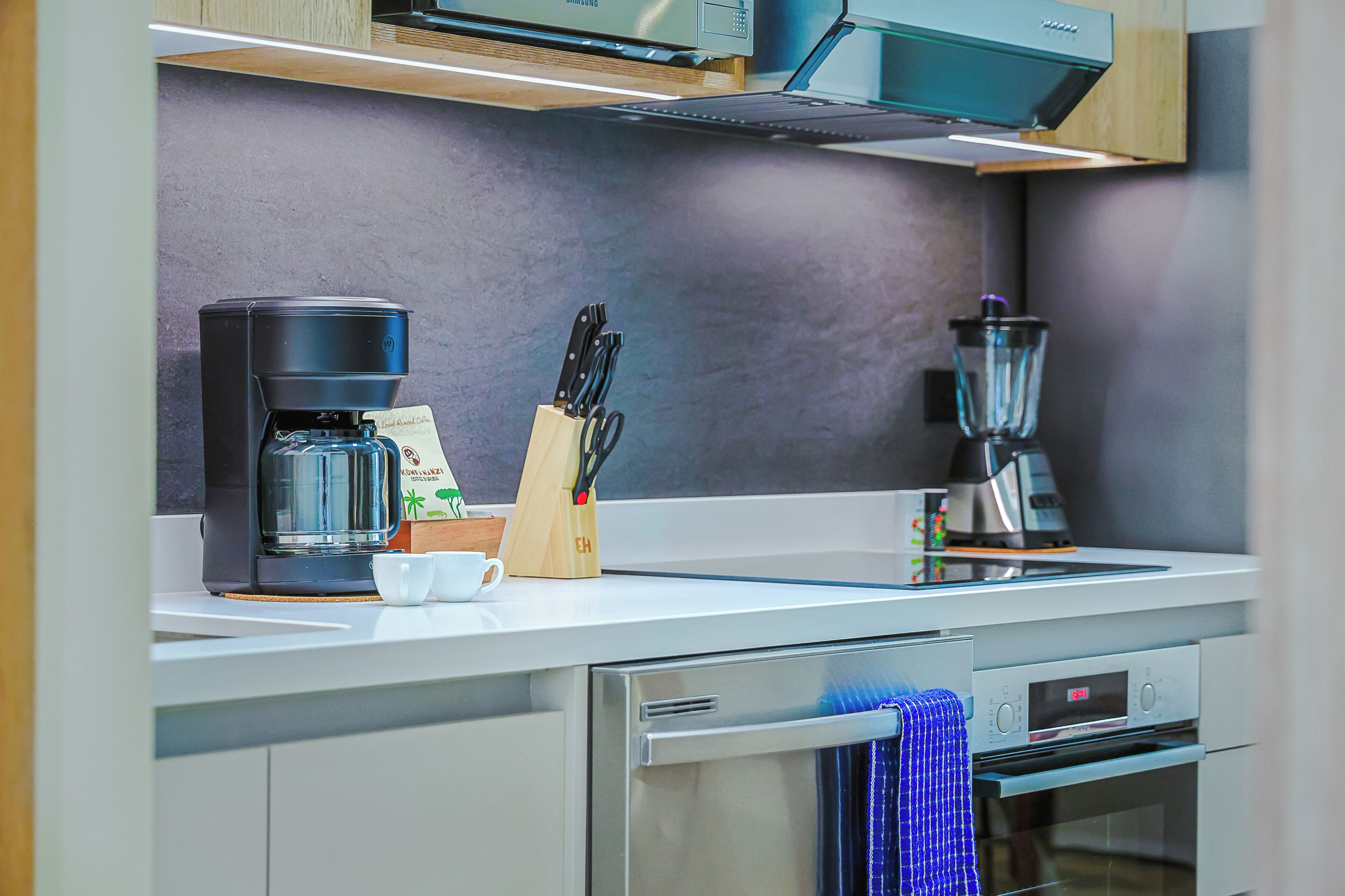 Une cuisine moderne équipée d’une machine à café, d’un mixeur et d’un bloc à couteaux.