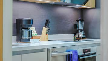 A modern kitchen with a coffee maker, a blender, and a knife block.