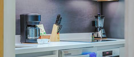 Een moderne keuken met een koffiezetapparaat, een blender en een messenblok.