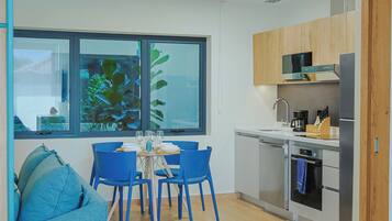 A modern kitchen with a dining area, featuring a large window, wooden cabinets, and a built-in microwave.