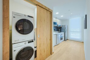 Uma cozinha moderna com eletrodomésticos embutidos, uma porta de madeira e vista para o exterior.