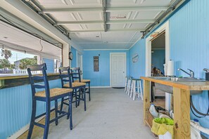 A compact kitchen with a bar area, wooden chairs, and a sink. - Blue Haven | Canal-front retreat | Boat-Slip (Galveston)