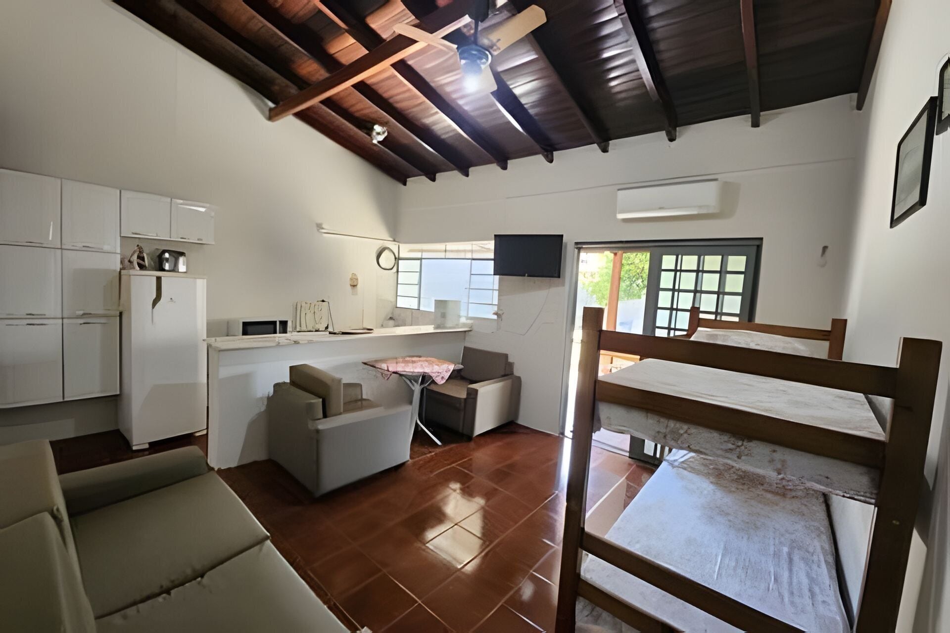 A compact kitchen with white cabinets, a refrigerator, and a dining area with a table and chairs.