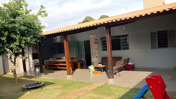 A covered patio area with a table and chairs, a slide, and a trampoline. - DOURADOS GUEST FLAT (Dourados)
