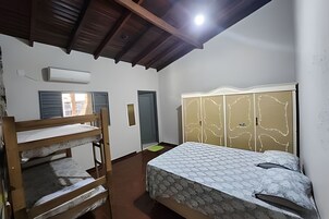 Una habitación con una cama litera, un armario con diseño estampado y una puerta.