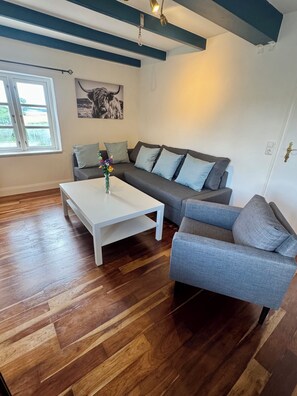 A living room with a white coffee table, grey sofa, and a grey armchair.