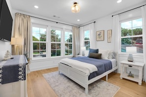 A bedroom with a bed, bedside tables, a lamp, and a window with curtains. - East Nash Luxe Minutes to Nissan Stadium & Five Points (Nashville)