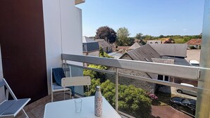 A balcony with a table, chairs, and a bottle. - La Madeleine - Balcon - Quartier Château (Bagnoles de l'Orne Normandie)