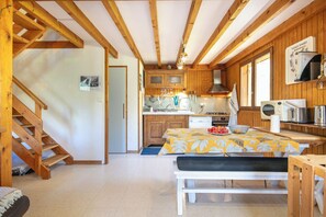 A wooden interior with a kitchen, dining area, and a staircase. - Le Lauzat - Petfriendly - Balcon (Villard-Reymond)