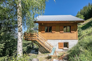 A wooden cabin with a staircase leading to a deck, surrounded by trees. - Le Lauzat - Petfriendly - Balcon (Villard-Reymond)