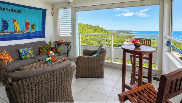 A balcony with a view of the ocean and a tropical landscape. - Melody - Climatisation - Proche plage (SAINTE ANNE)