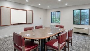 A conference room with a large table, red chairs, a whiteboard, and large windows. - Accessible 1BR King Suite | Free Breakfast + Pool (Allentown)