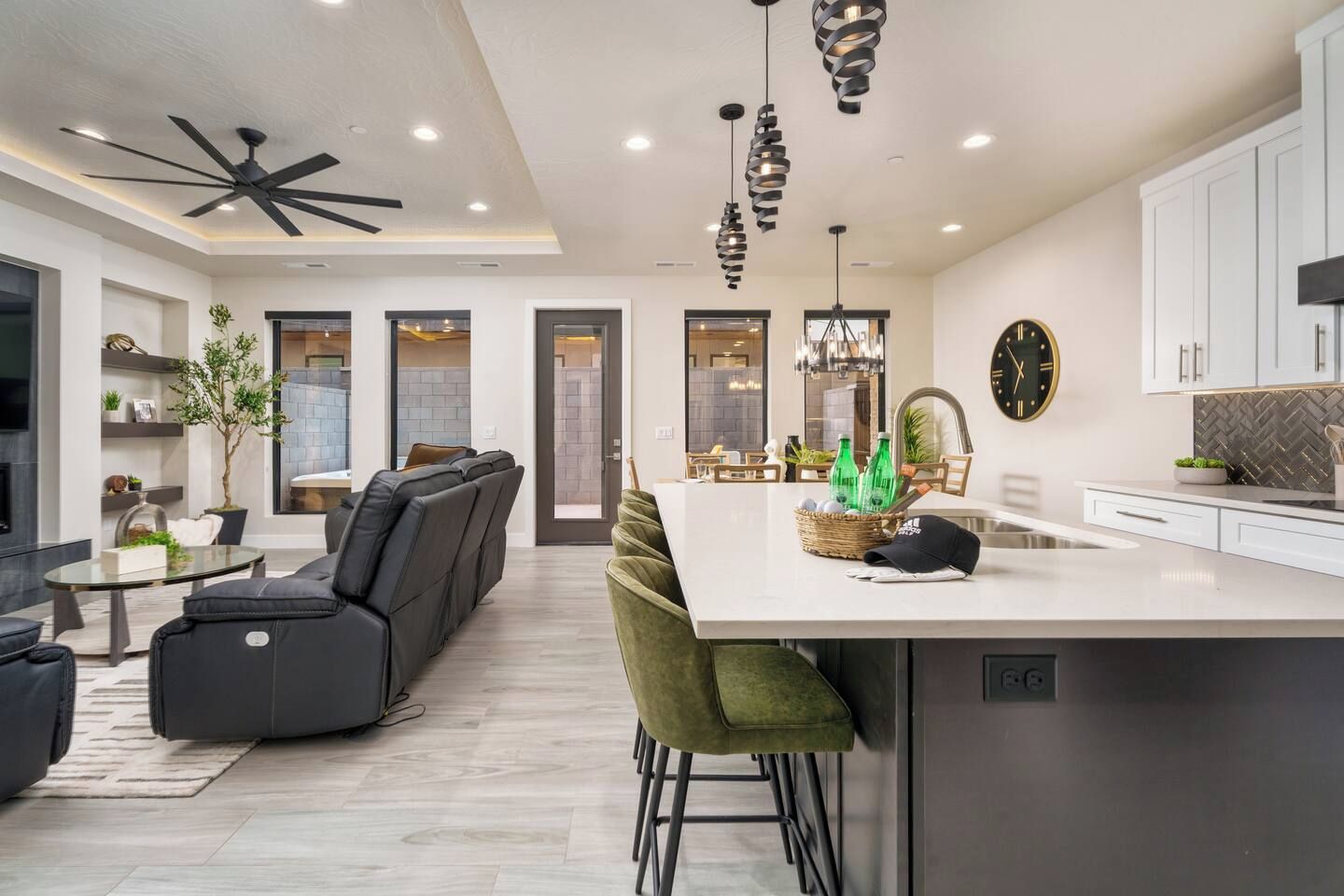 A modern kitchen with a central island, bar stools, and pendant lighting.