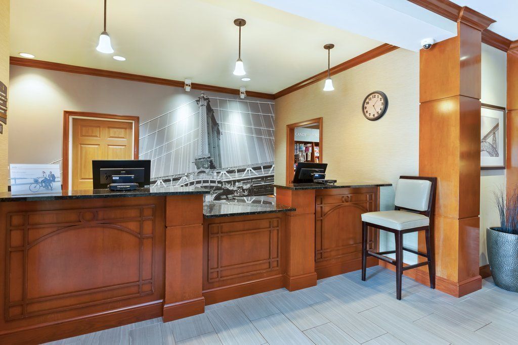 A kitchen with wooden cabinetry, a built-in island, pendant lighting, a clock on the wall, and a potted plant.