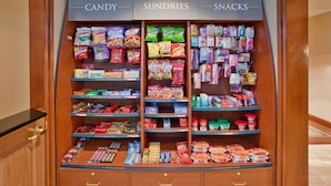 Exhibición de dulces, artículos varios y bocadillos en una tienda.