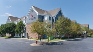 A hotel with a stone facade and a blue roof, featuring a prominent 'CANDLEWOOD' sign.