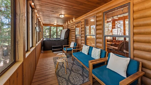 A log cabin interior with a cozy seating area, a fireplace, and large windows. - Dogwood Lodge - Hot Tub, Near Kerith House Winery (Morganton)