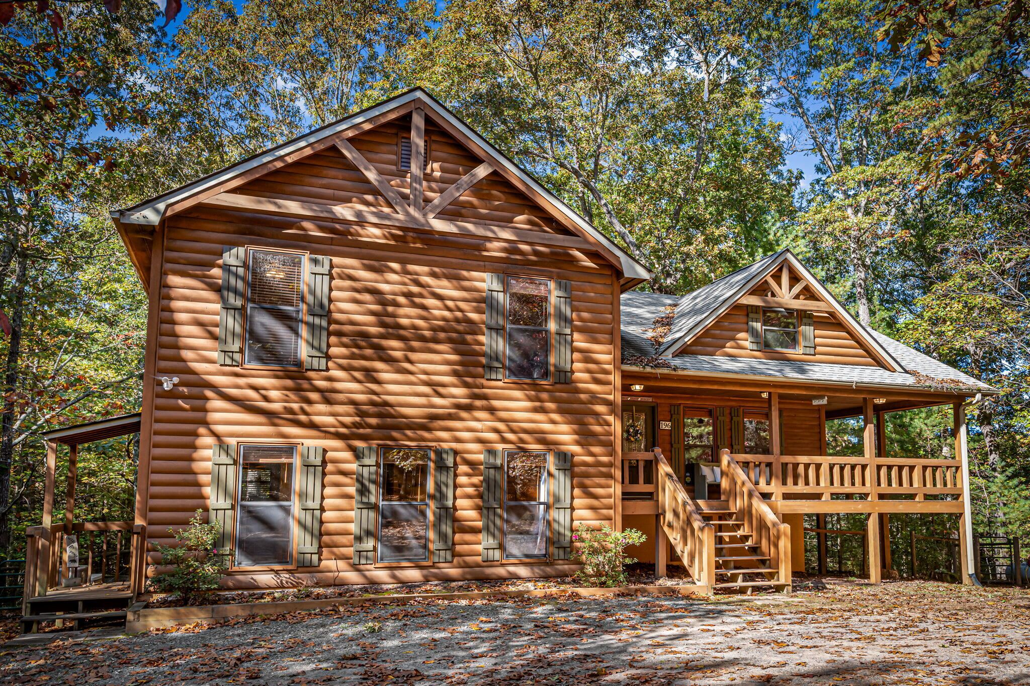 A log cabin with a porch and a staircase leading to a covered area.