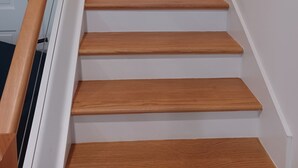 A staircase with wooden steps and a wooden handrail. - Charming 1-bedroom bungalow with AC in Oak Bluffs (Oak Bluffs)
